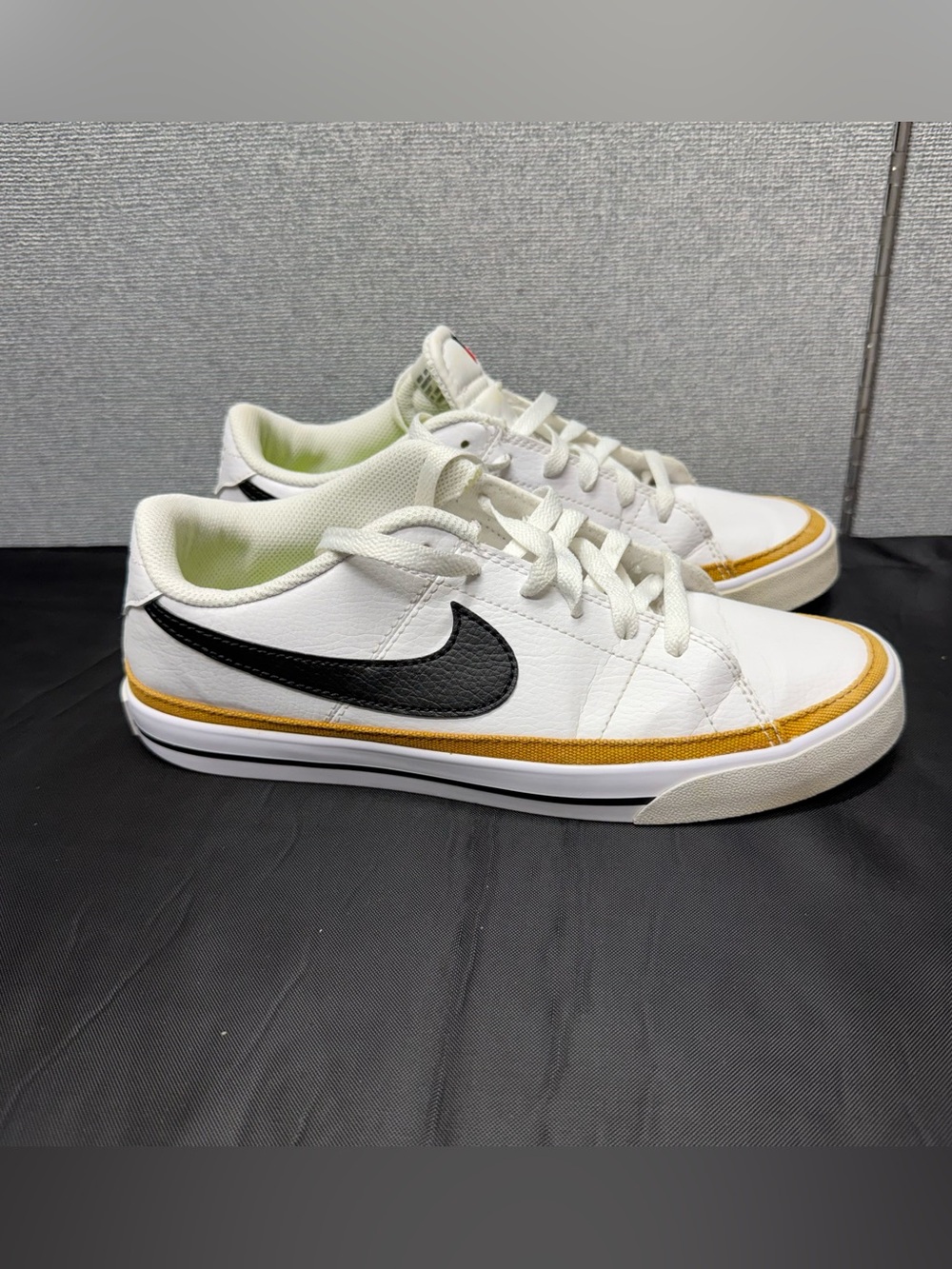 Nike White Low Top Sneakers with Black Swoosh and Yellow Trim